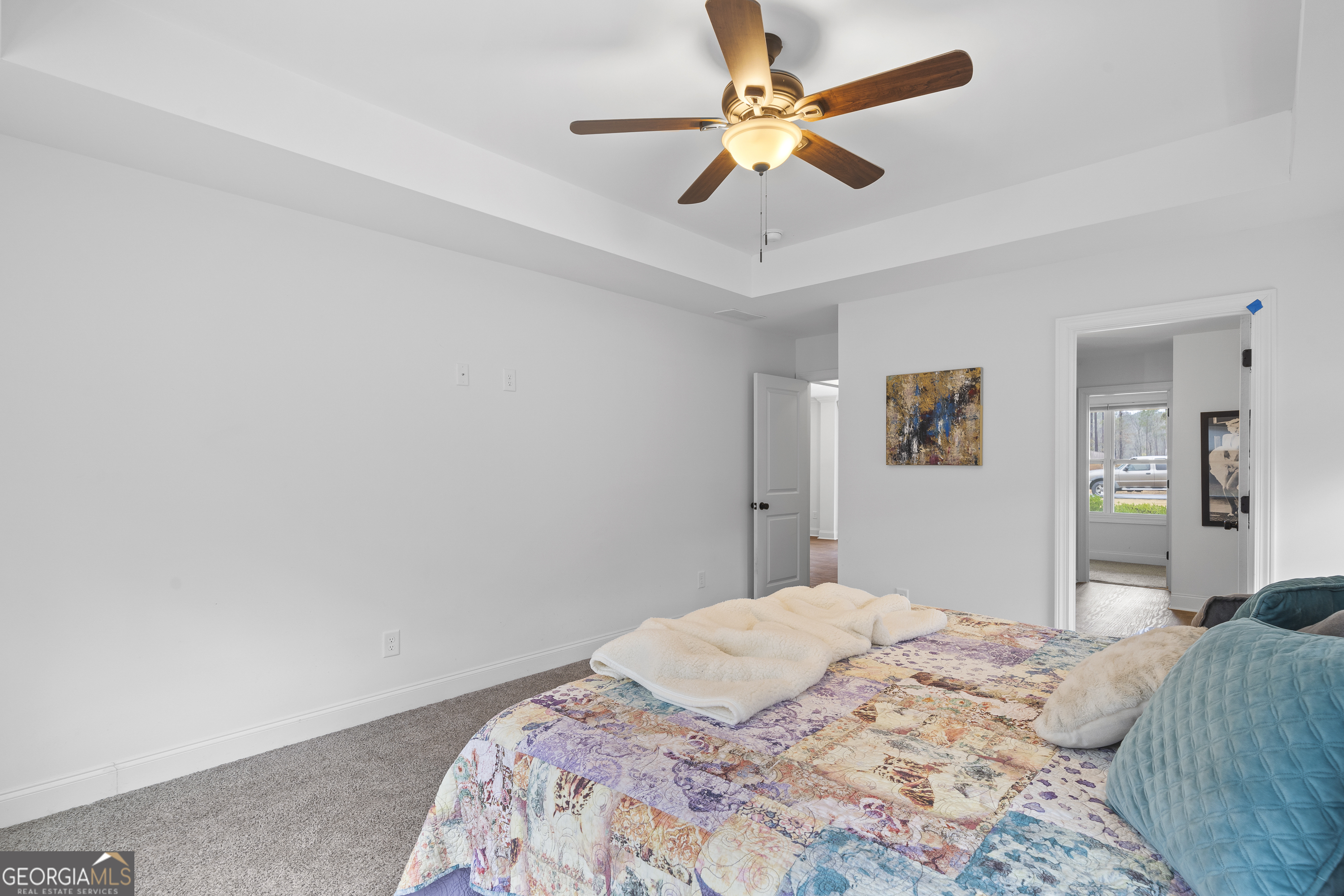 149 Willow Forest Road Milledgeville, GA 31061 - Photo 18 of 52 a bedroom with a large bed and a chandelier