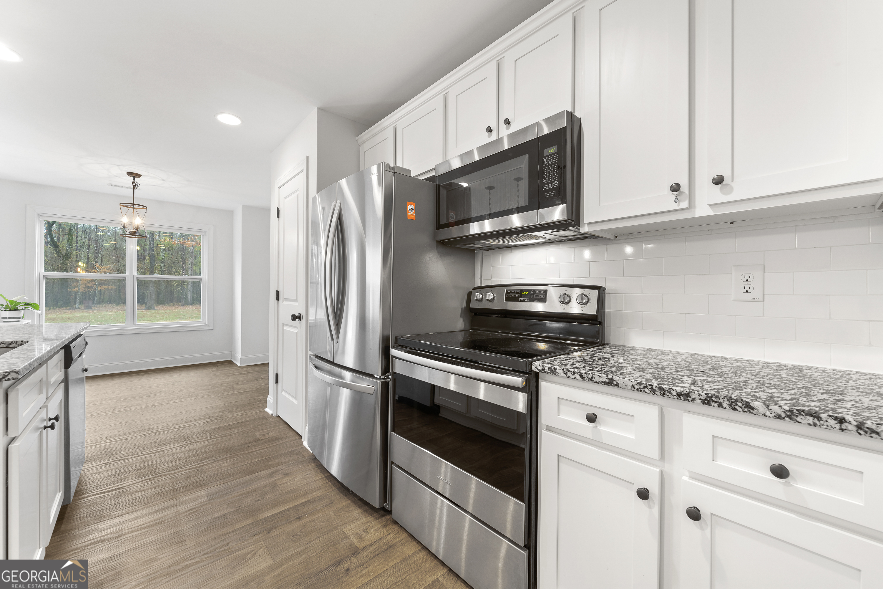 149 Willow Forest Road Milledgeville, GA 31061 - Photo 33 of 52 a kitchen with stainless steel appliances granite countertop a stove a microwave and a white cabinets