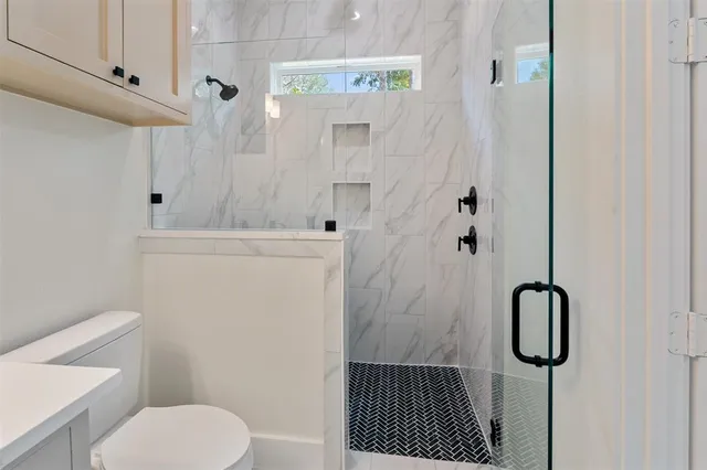 a bathroom with a toilet and a shower