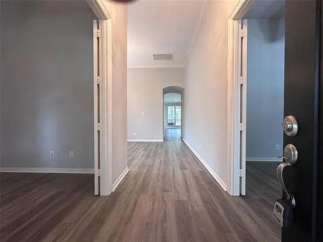 a view of a hallway with wooden floor and staircase