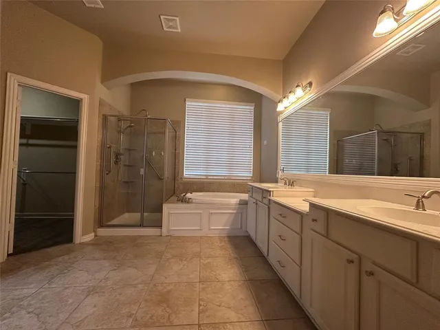 a spacious bathroom with a mirror a bathtub and a shower