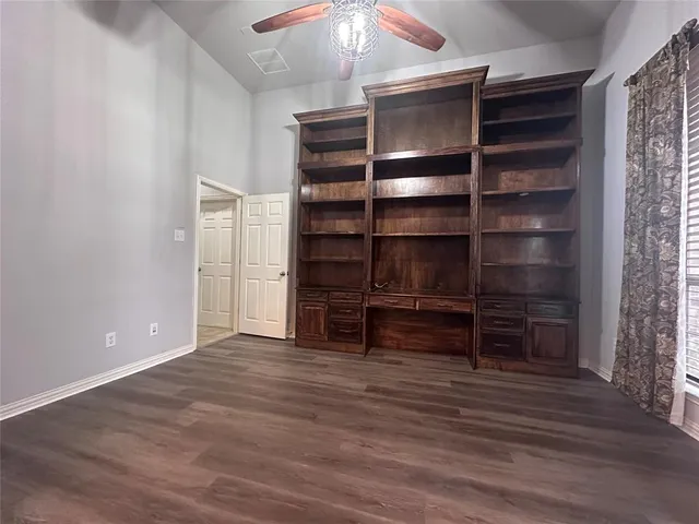 a view of an empty room with a furniture and a window