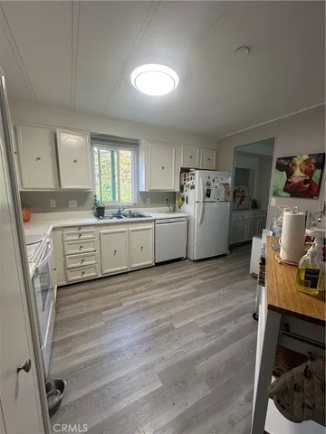 a kitchen with a sink cabinets and wooden floor