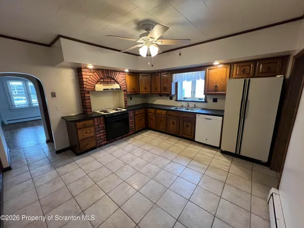 a large kitchen with a stove a sink dishwasher and a refrigerator