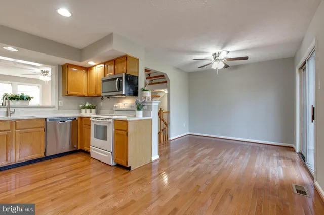 a kitchen with stainless steel appliances granite countertop a sink cabinets and wooden floor