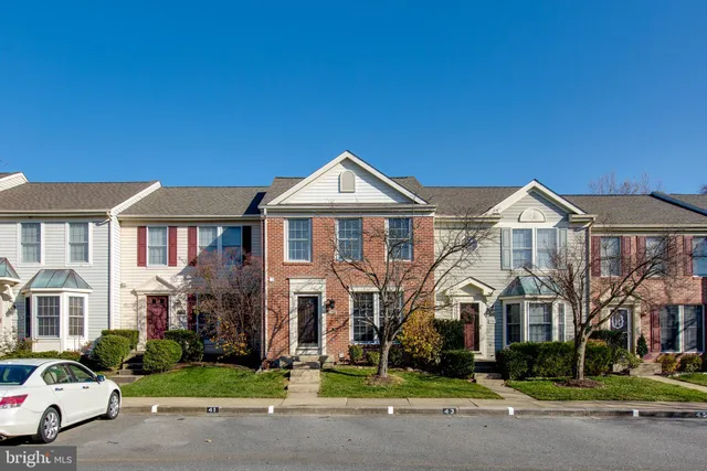 a view of a big house with a yard and plants