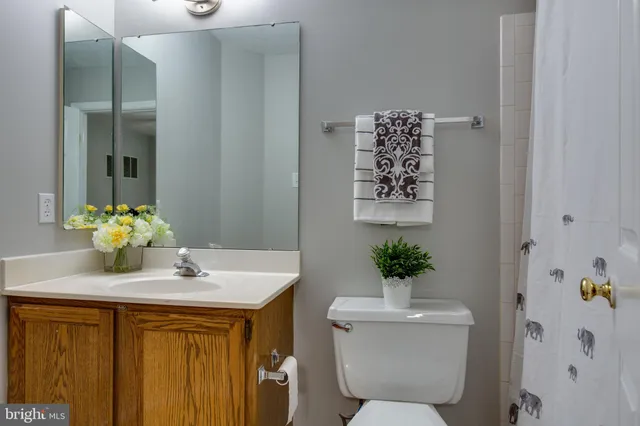 a bathroom with a granite countertop sink a toilet and a mirror