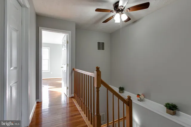 a view of a hallway with wooden floor and entryway