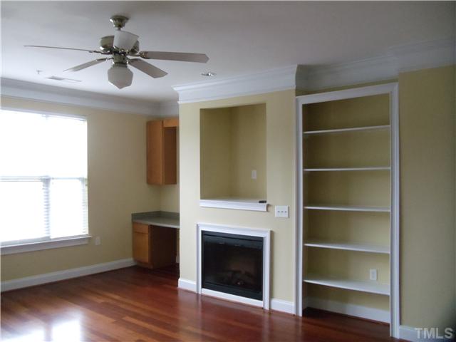 3811 Lunceston Way, Unit 305 Raleigh, NC 27613 - Photo 7 of 25 Family room has brazilian cherry floors, built-in book case and desk & cabinet storage flank gas log fireplace. Upgrade window blinds throughout the home.