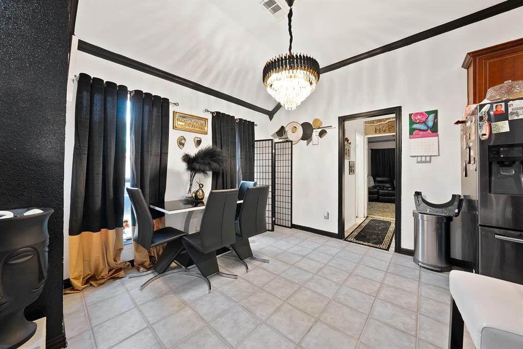 2716 Rochelle Point Irving, TX 75062 - Photo 23 of 40 Vaulted ceiling featuring a tiered chandelier, tile flooring, and a stainless steel refrigerator