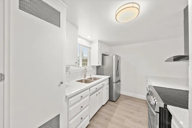 a kitchen with stainless steel appliances granite countertop a sink and a refrigerator