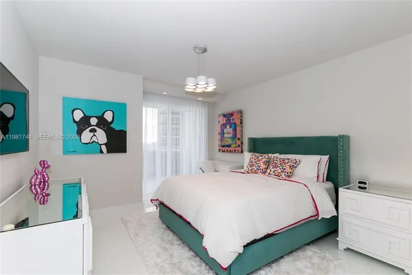 a bedroom with a bed and a chandelier