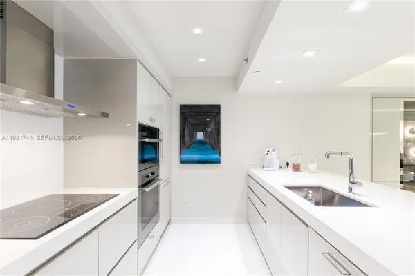 a kitchen with a sink and white cabinets