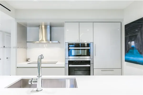 a kitchen with kitchen island granite countertop a refrigerator and a sink