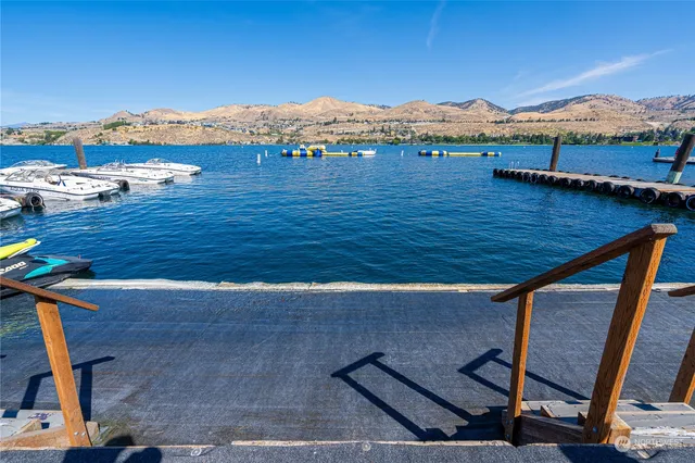 a view of a house with a parking space and a mountain view in front of it