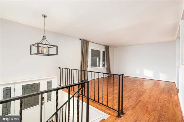 a view of hallway with stairs and wooden floor