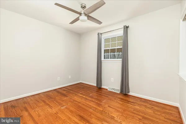 an empty room with a window and wooden floor