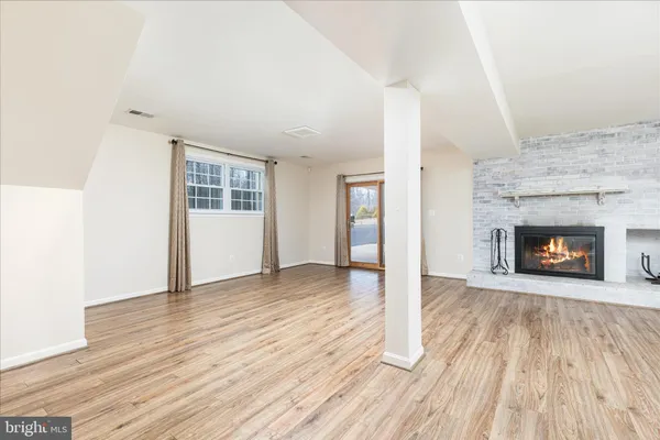 an empty room with wooden floor and fireplace