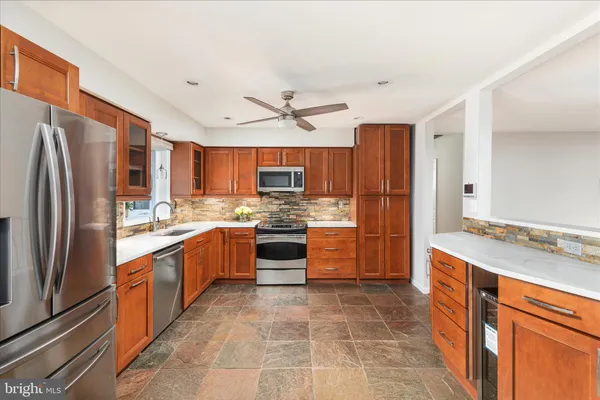 a kitchen with stainless steel appliances granite countertop a refrigerator and a stove top oven