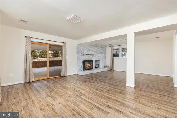 a view of empty room with wooden floor and fireplace