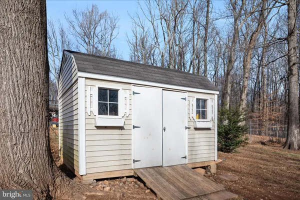 a front view of a house with a garden and trees