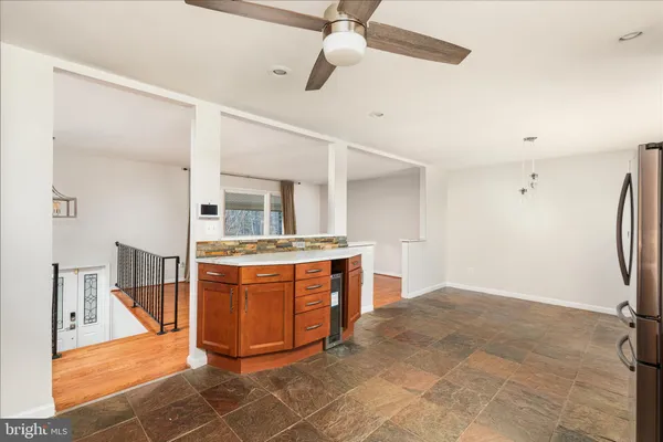a room with stainless steel appliances kitchen island granite countertop a stove a refrigerator and cabinets