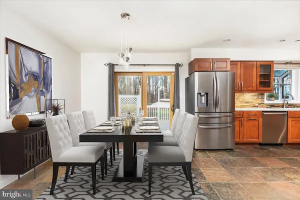 a kitchen with stainless steel appliances kitchen island granite countertop a dining table and chairs