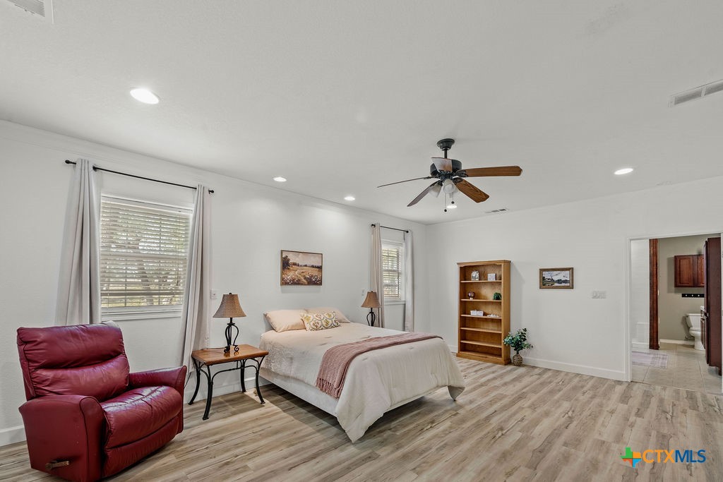 2795 Highway 290 Dripping Springs, TX 78620 - Photo 15 of 40 a bedroom with a bed and wooden floor