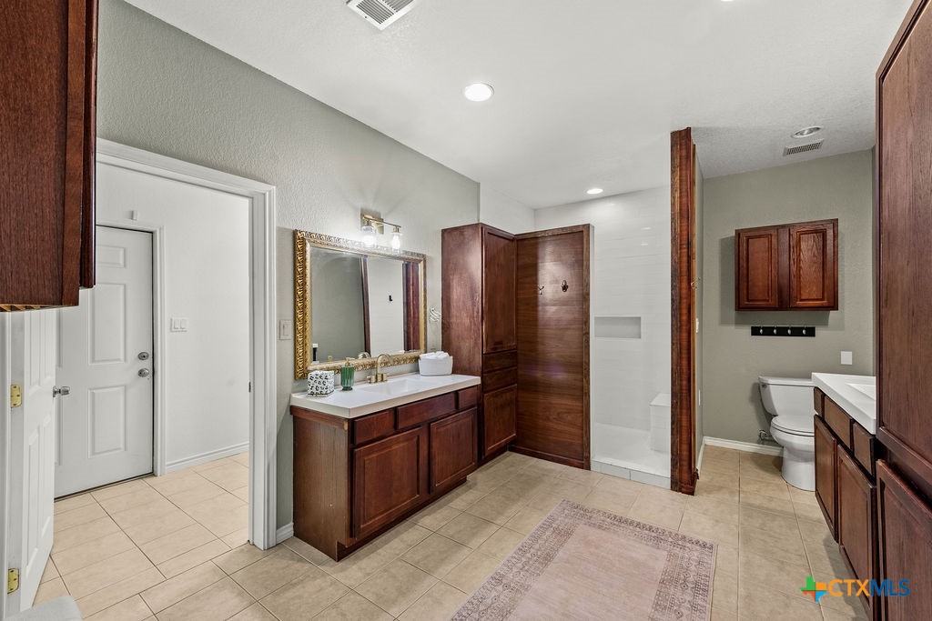2795 Highway 290 Dripping Springs, TX 78620 - Photo 17 of 40 a bathroom with a sink toilet and shower