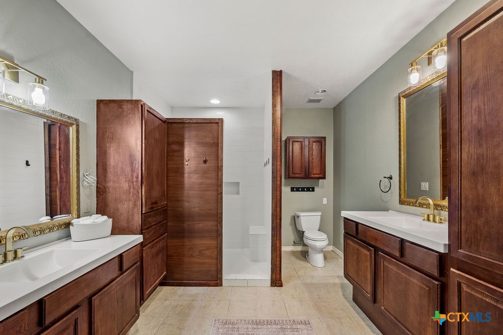 2795 Highway 290 Dripping Springs, TX 78620 - Photo 18 of 40 a bathroom with a sink a toilet and shower