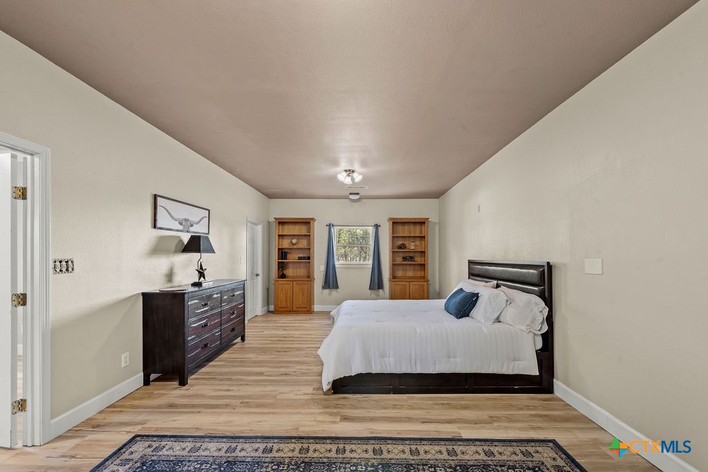 2795 Highway 290 Dripping Springs, TX 78620 - Photo 20 of 40 a bedroom with a large bed and a dresser