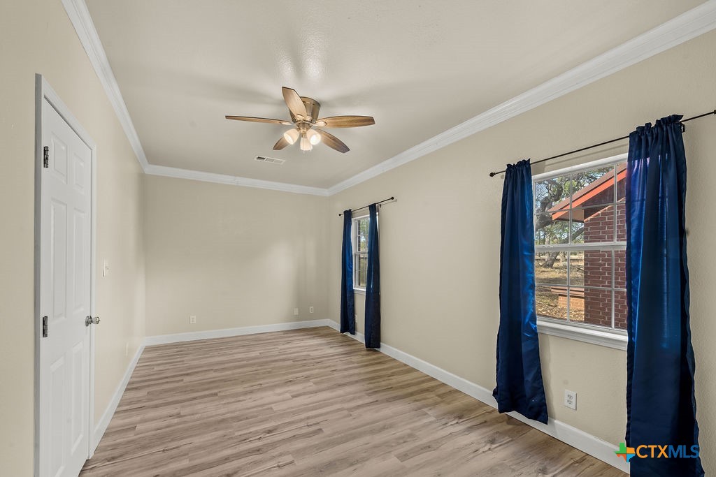 2795 Highway 290 Dripping Springs, TX 78620 - Photo 21 of 40 a view of empty room with wooden floor and fan