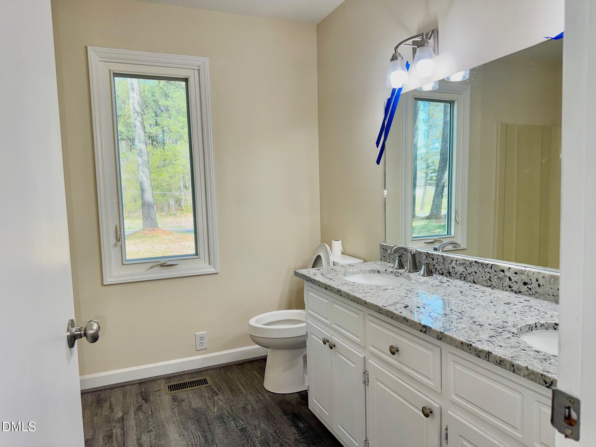 1720 Ross Mill Road Henderson, NC 27537 - Photo 28 of 42 a bathroom with a granite countertop sink toilet and mirror