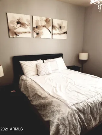 a bedroom with a bed and painting on the wall