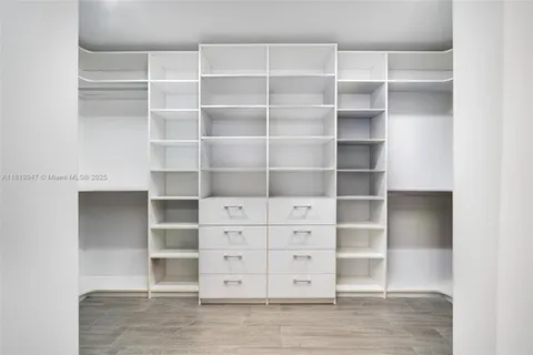 a bedroom with a large bed and wooden floor