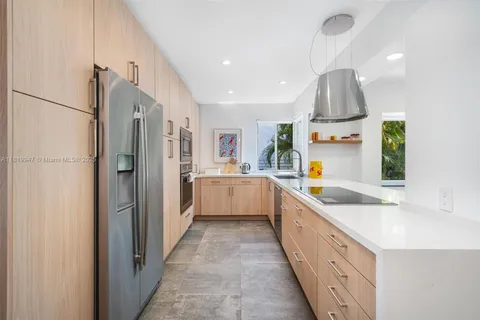 a large kitchen with a sink and refrigerator