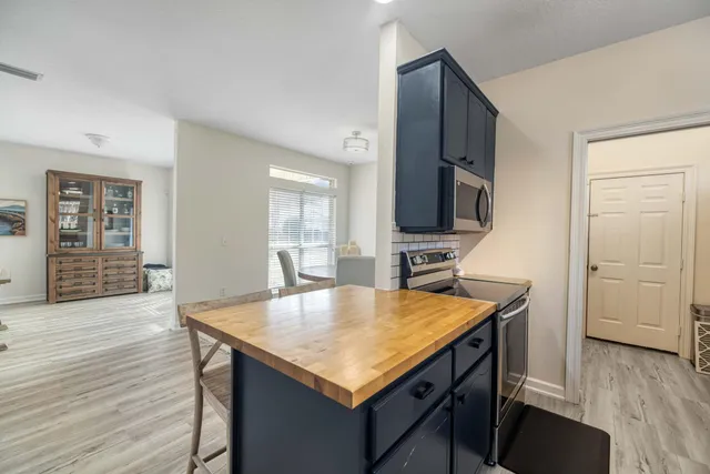 a kitchen with kitchen island a sink appliances and wooden floor