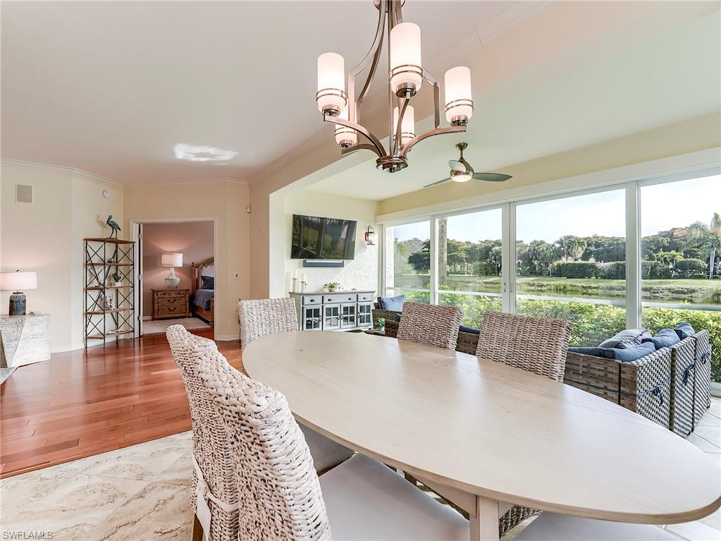 22921 Rosedale Drive, Unit 102 Estero, FL 34135 - Photo 13 of 33 a view of a dining room with furniture wooden floor and chandelier