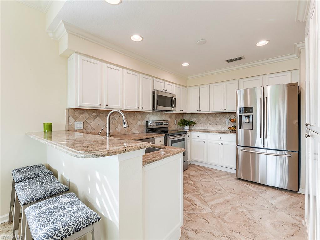 22921 Rosedale Drive, Unit 102 Estero, FL 34135 - Photo 15 of 33 a kitchen with a refrigerator sink and microwave