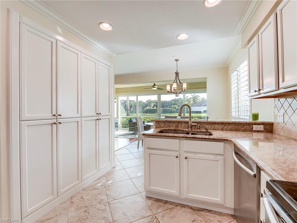 22921 Rosedale Drive, Unit 102 Estero, FL 34135 - Photo 17 of 33 a kitchen with granite countertop a sink and white cabinets