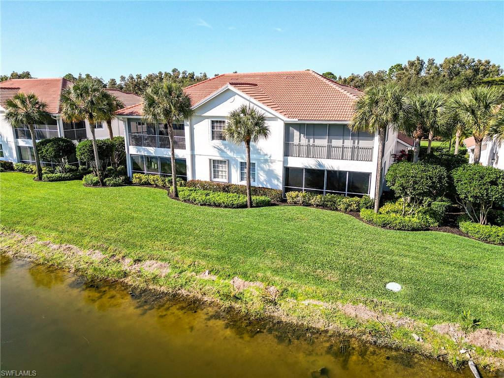 22921 Rosedale Drive, Unit 102 Estero, FL 34135 - Photo 33 of 33 a front view of a house with a yard table and chairs