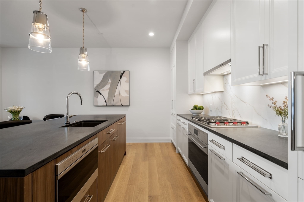 100 Linden Street, Unit 102 Wellesley, MA 02482 - Photo 2 of 30 a kitchen that has a sink and a stove