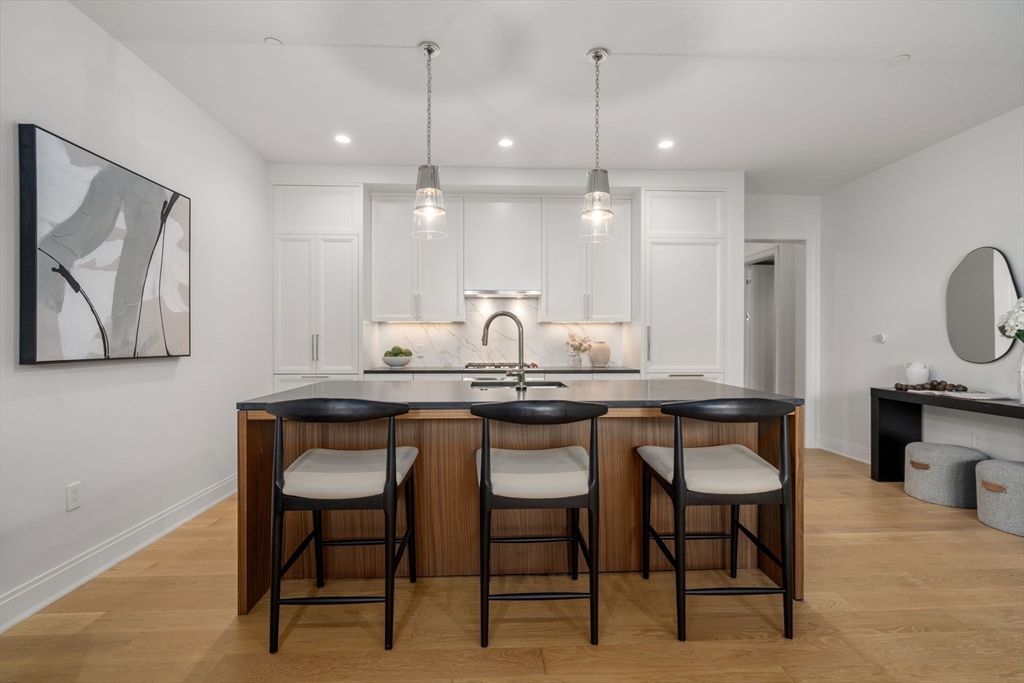 100 Linden Street, Unit 102 Wellesley, MA 02482 - Photo 3 of 30 a kitchen with granite countertop a sink cabinets and stainless steel appliances