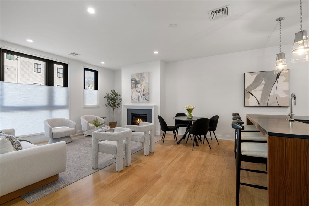 100 Linden Street, Unit 102 Wellesley, MA 02482 - Photo 5 of 30 a living room with furniture a fireplace and a table