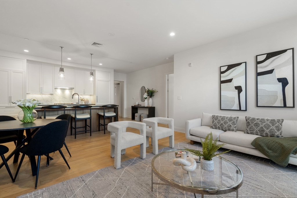 100 Linden Street, Unit 102 Wellesley, MA 02482 - Photo 8 of 30 a living room with furniture and a dining table with wooden floor