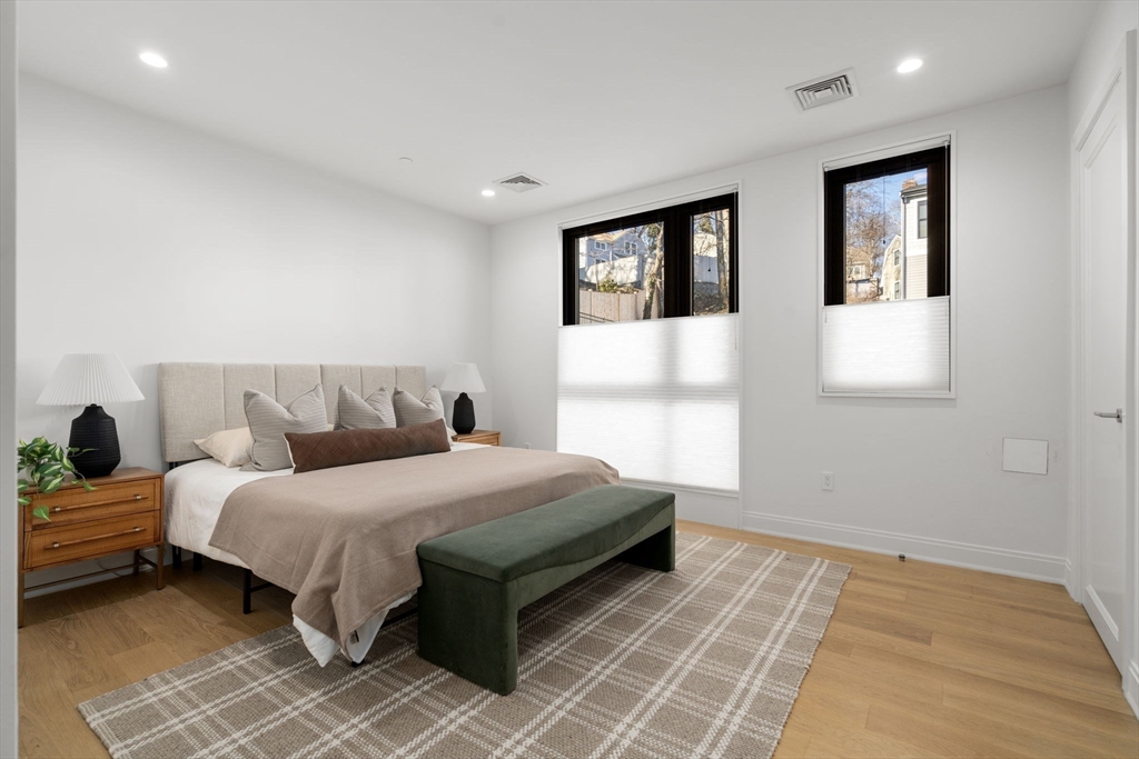100 Linden Street, Unit 102 Wellesley, MA 02482 - Photo 9 of 30 a bedroom with a bed and a night stand
