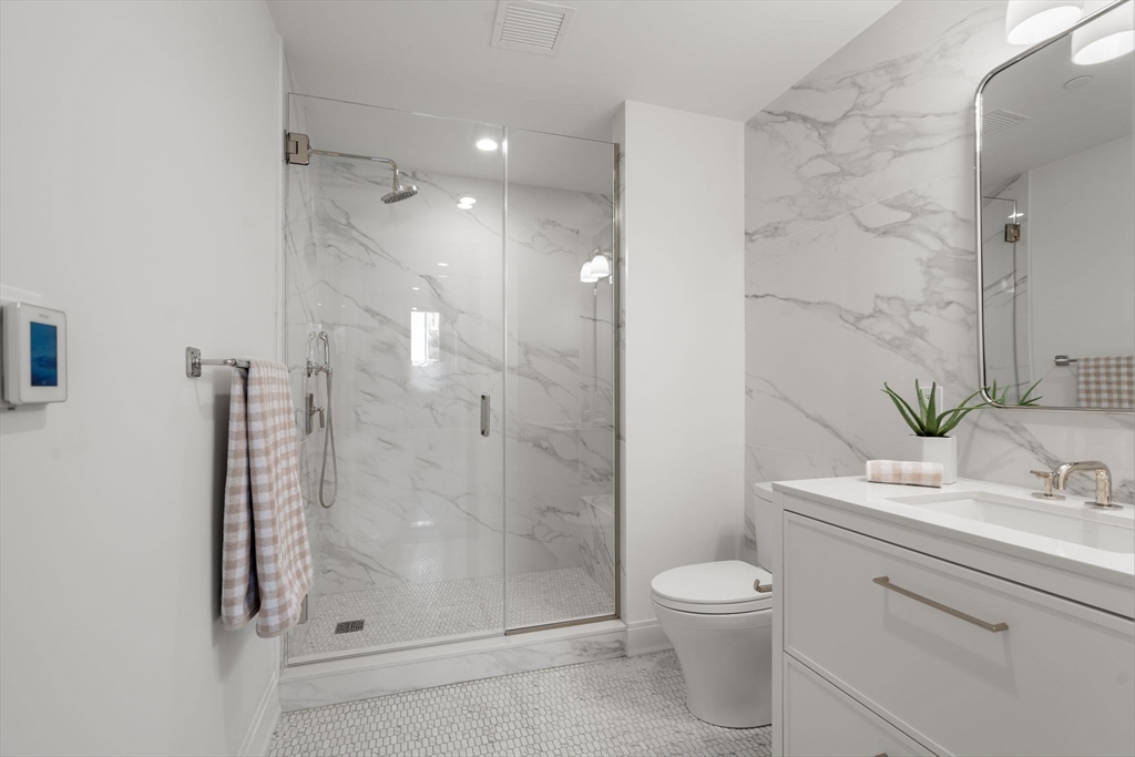 100 Linden Street, Unit 102 Wellesley, MA 02482 - Photo 10 of 30 a bathroom with a granite countertop sink a toilet and shower