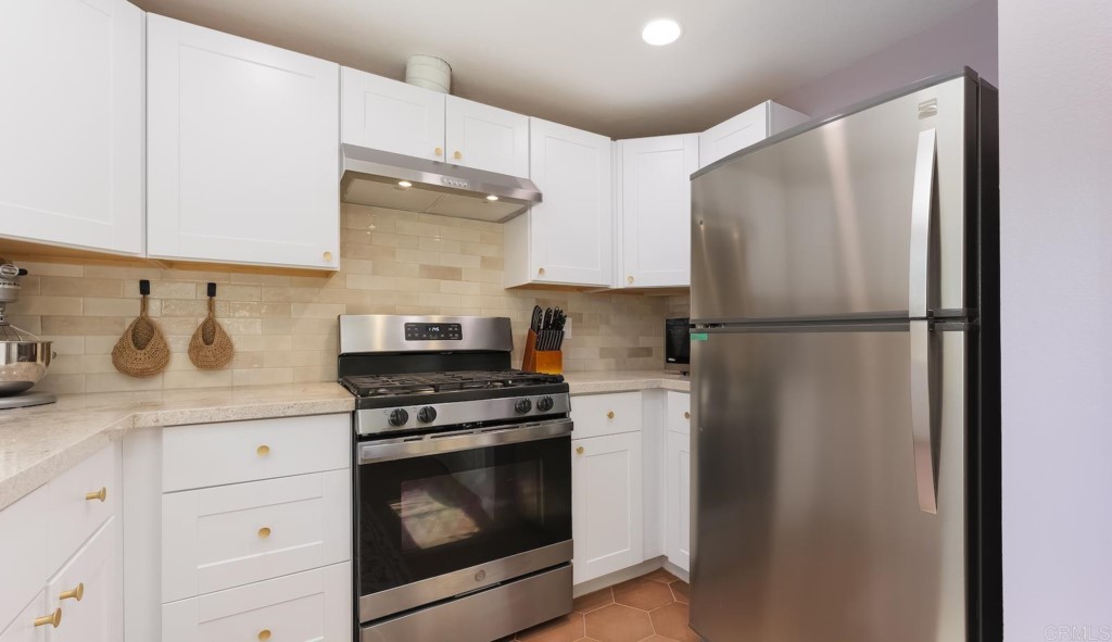 322 Ivy Lane Fallbrook, CA 92028 - Photo 12 of 35 a kitchen with stainless steel appliances granite countertop a refrigerator stove and white cabinets