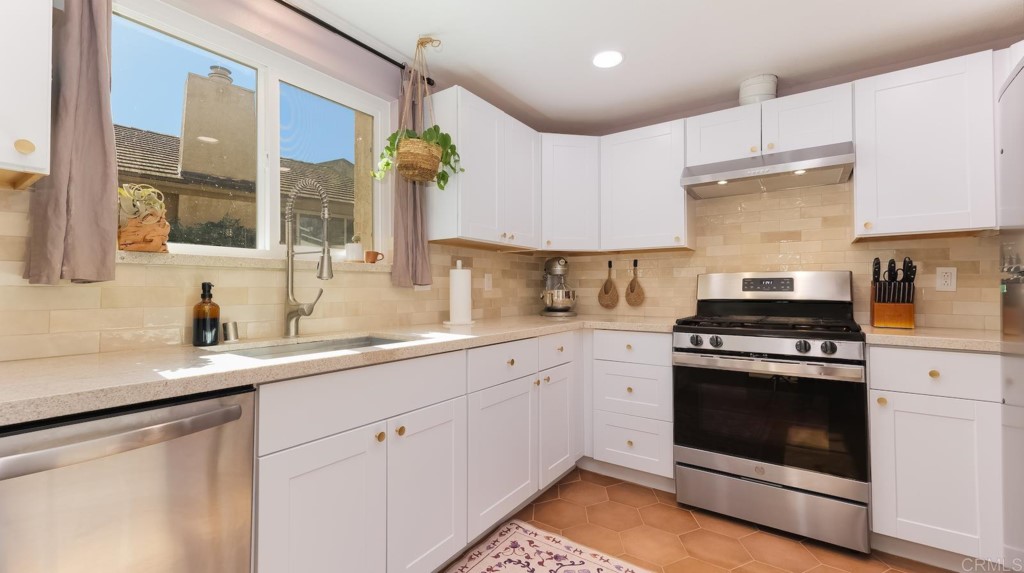 322 Ivy Lane Fallbrook, CA 92028 - Photo 13 of 35 a kitchen with granite countertop white cabinets stainless steel appliances and sink