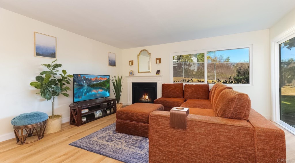 322 Ivy Lane Fallbrook, CA 92028 - Photo 6 of 35 a living room with furniture a flat screen tv and a fireplace